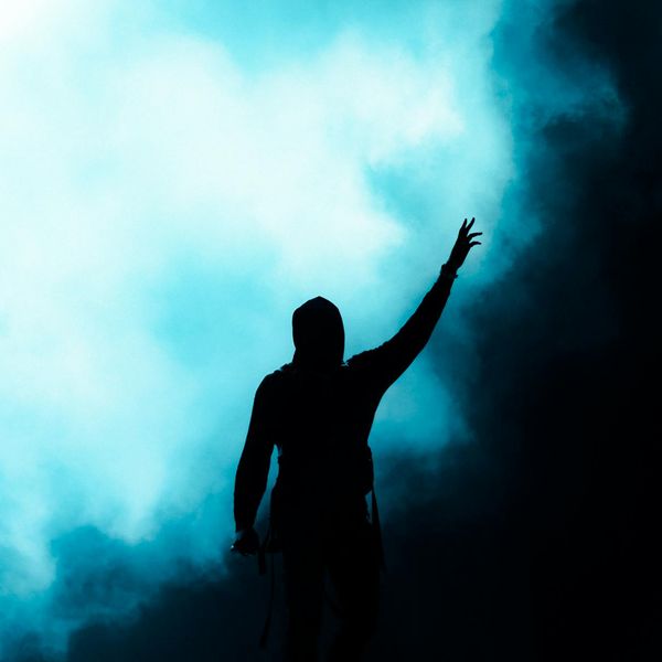 Silhouette of a person in a powerful stance against a sunrise.